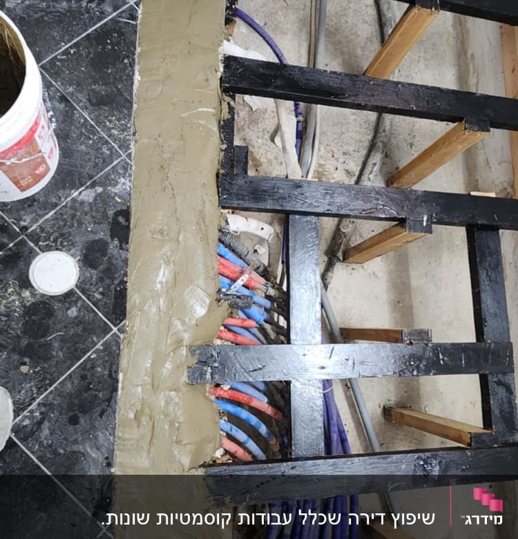 צינורות צבעוניים מתחת לרצפה עם קורות עץ וברזל